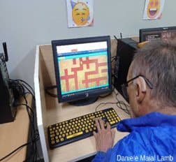 Aluno da EJA usando as setas do teclado para percorrer o labirinto na tela.
