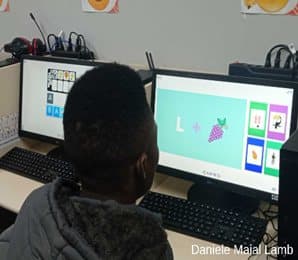 Aluno da EJA acompanhando na tela as pistas visuais do jogo de codificação.