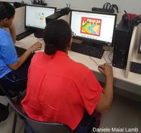 Alunos concentrados na atividade de pintura digital das obras do acervo.